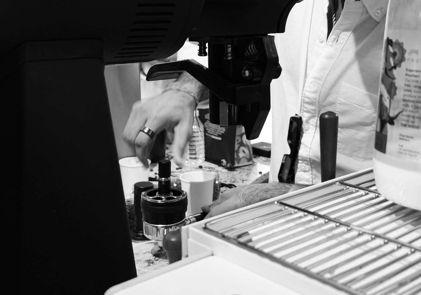 Barista's hands making a coffee drink with an espresso machine.