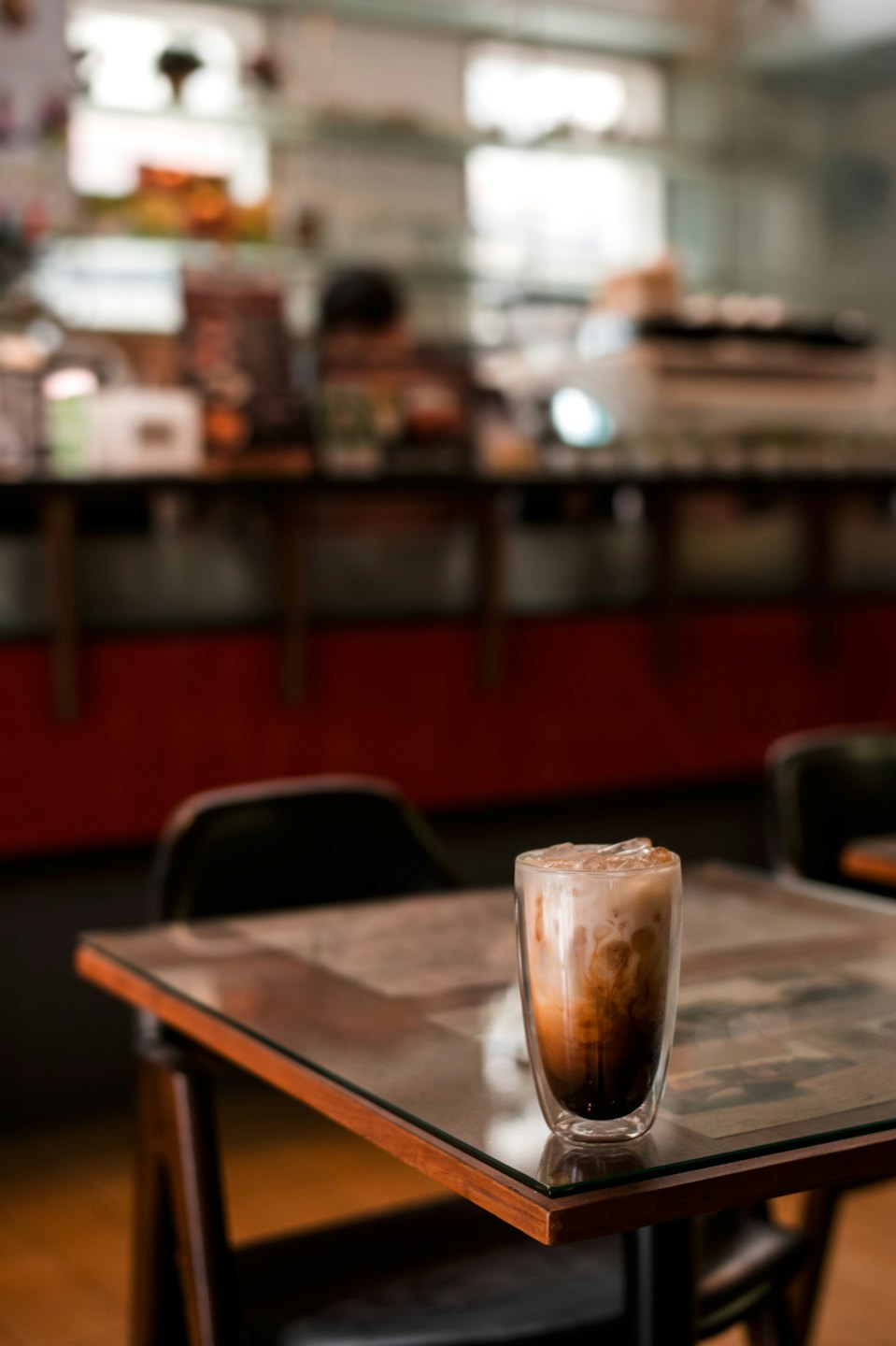 Iced coffee layered with espresso and cream on a wooden table.